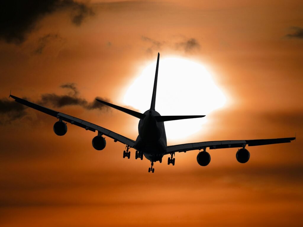 aircraft-holiday-sun-tourism-104826-104826 Dramatic silhouette of an airplane flying against a vibrant sunset sky.