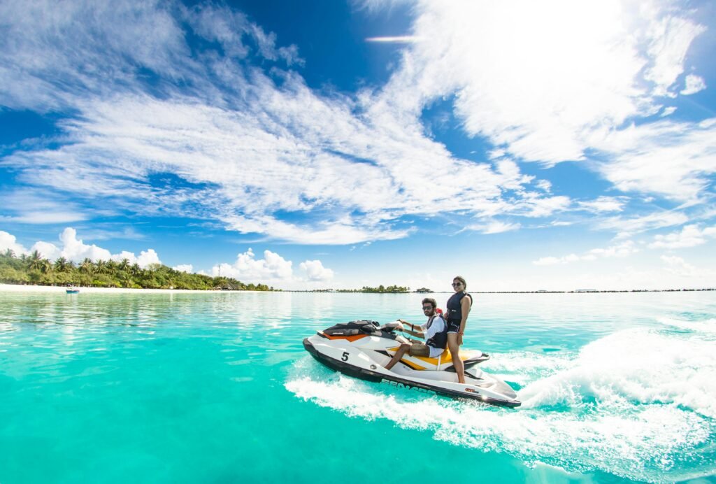 pexels-photo-1430676-1430676 Couple enjoying a thrilling jet ski ride on crystal clear waters under a bright sky in Maldives.