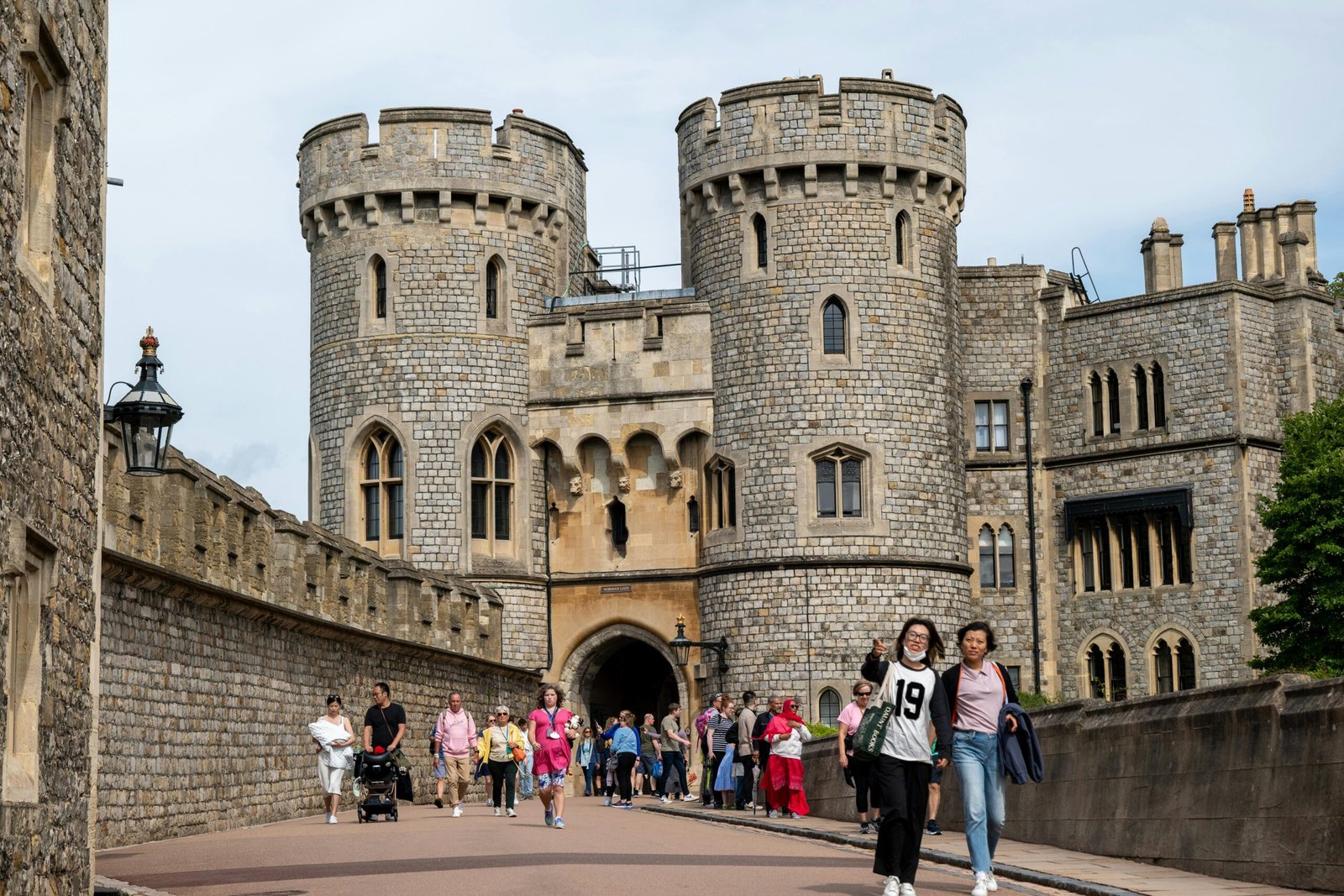 A lively scene with tourists exploring the medieval Windsor Castle in England.